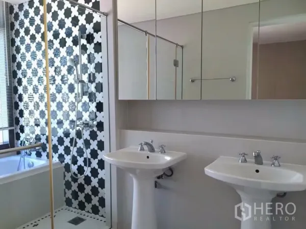 คอนโด ให้เช่าในKhlong Toei, Bangkok - ห้องน้ำโมเดิร์นมีอ่างล้างหน้าคู่ กระจกบานตู้ และผนังกระเบื้องลายขาวดำ พร้อมอ่างอาบน้ำ