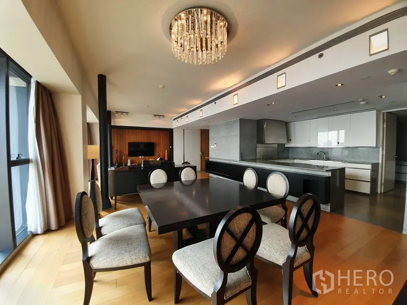 公寓 出租在Sathon, Bangkok - 餐厅与开放式厨房相连，设岛台与水晶吊灯。
