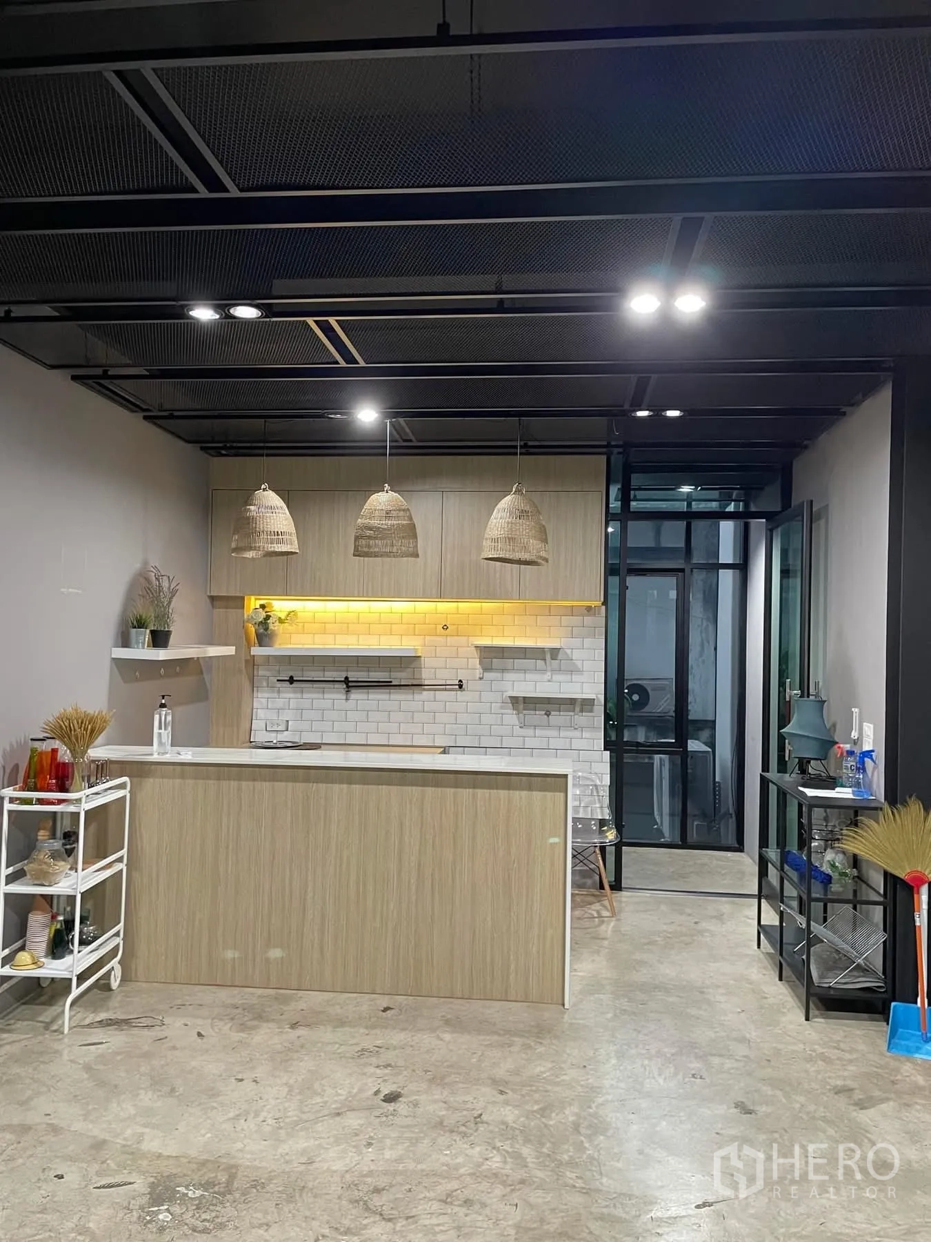 办公空间 出租在Khlong Toei, Bangkok - 茶水间，浅木色吧台、白色地铁砖墙与吊灯。