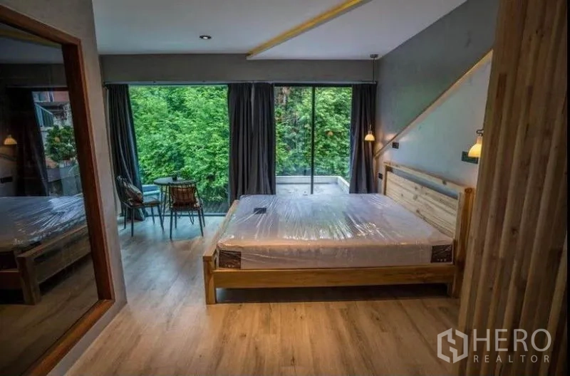 ทาวน์เฮาส์ ให้เช่าในKhlong Toei, Bangkok - ห้องนอนเตียงไม้ กระจกเต็มบาน ระเบียงนั่งเล่น มุมมองต้นไม้ร่มรื่น