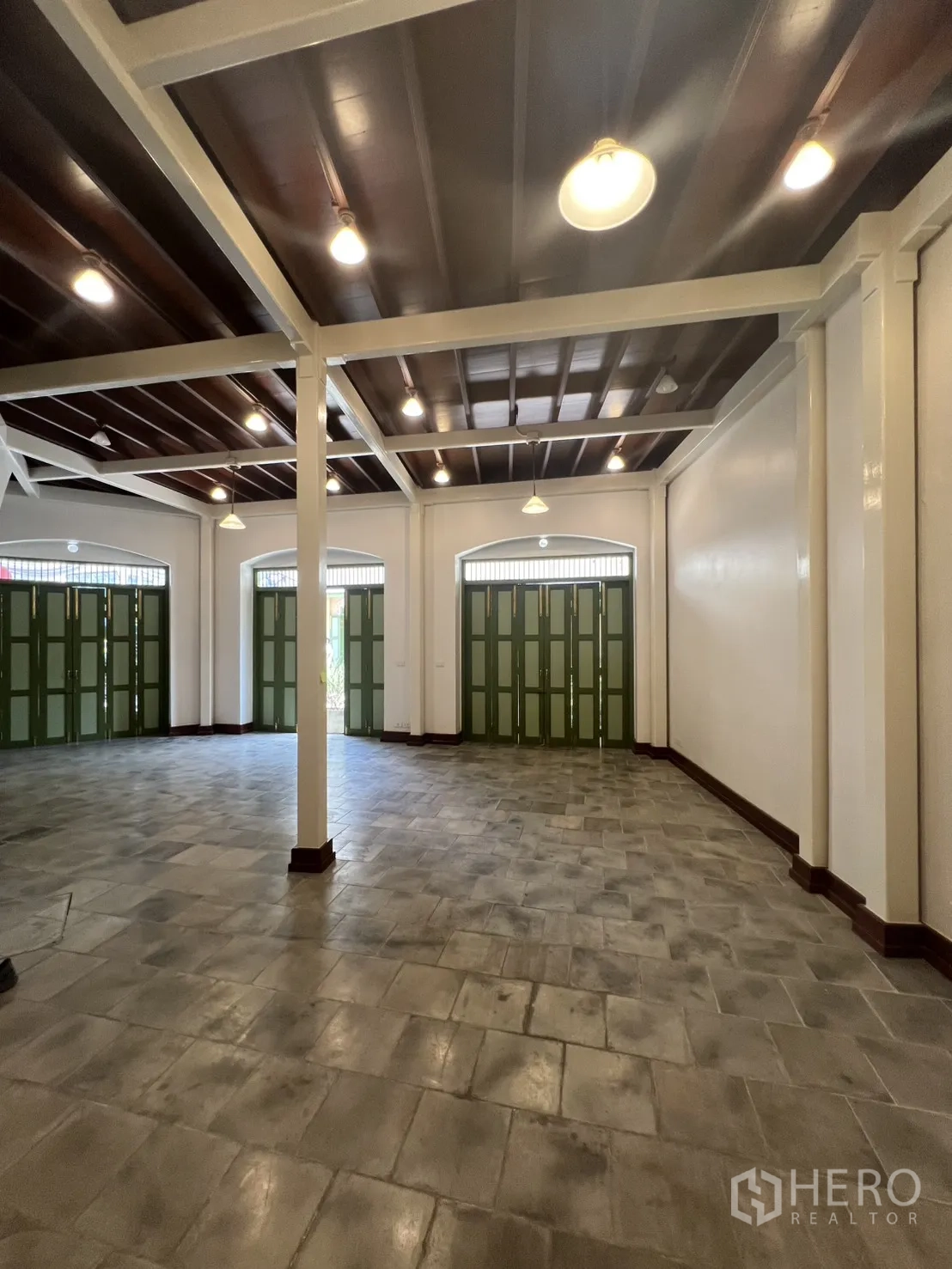 Shophouse for rent in Samphanthawong, Bangkok - Wide shop area showcasing exposed beam ceiling, ample lighting and expansive tiled flooring with several front doors.