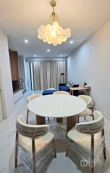 ทาวน์เฮาส์ ให้เช่าในSuan Luang, Bangkok - มุมทานอาหาร โต๊ะกลม โคมไฟระยุดีไซน์ และมุมมองไปยังห้องนั่งเล่น