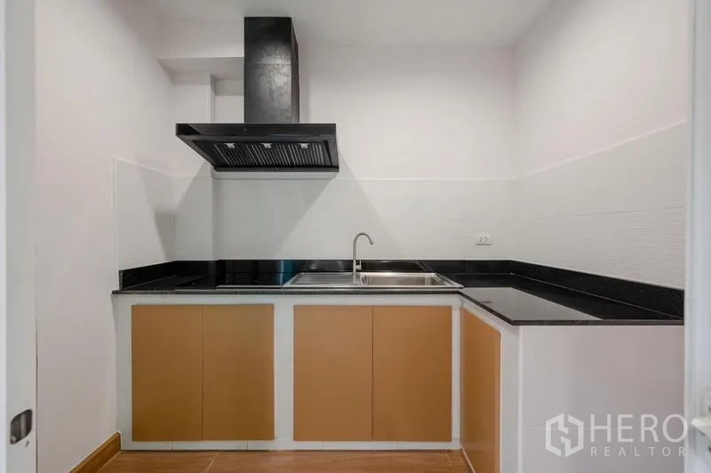 ทาวน์เฮาส์ ขายในLat Phrao, Bangkok - ครัวปิดเคาน์เตอร์หินสีดำ อ่างล้างจาน และเครื่องดูดควัน