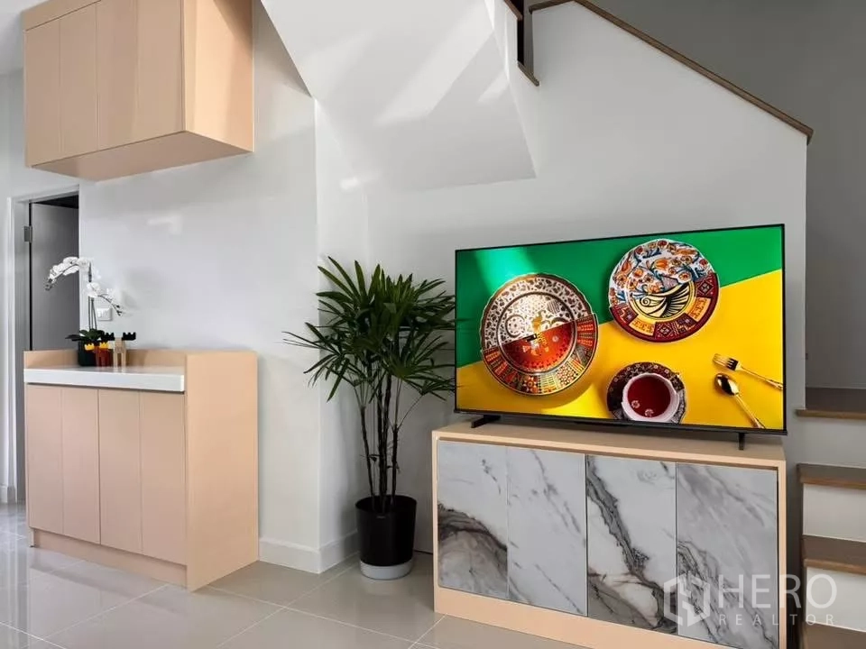 Townhouse for rent in Bang Phli, Samut Prakan - Marble-front TV cabinet beside built-in storage and indoor plant