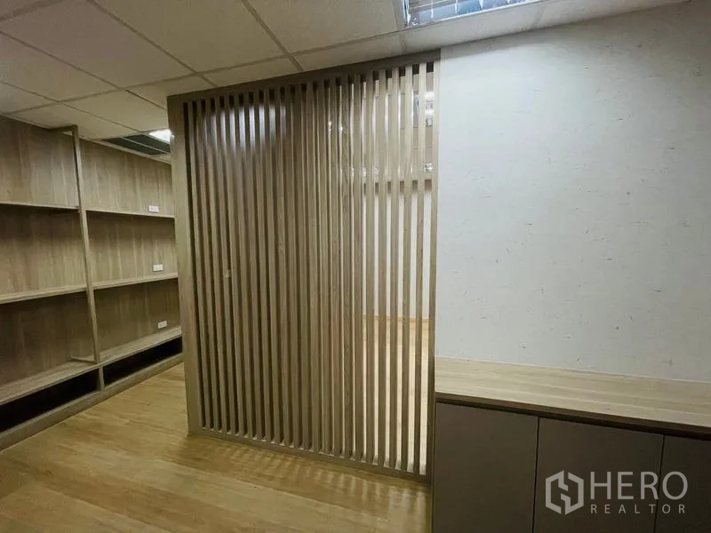 Office Space for rent - Wood slat divider and wall shelving creating a semi‑private workspace within the office.
