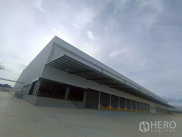 工厂 出租在Si Racha, Chon Buri - 泰国是拉差全新独栋工厂外观，长排有顶装卸区与宽阔混凝土场地。