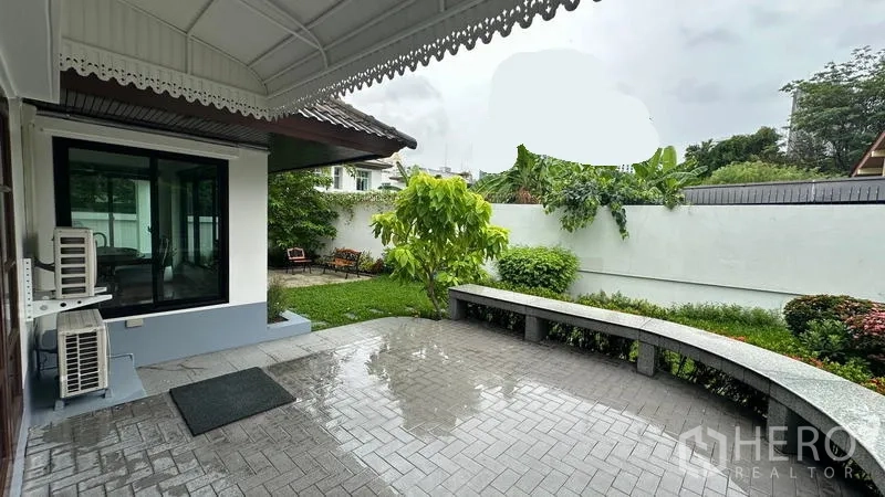 独立式住宅 出租在Watthana, Bangkok - 覆顶露台俯瞰草坪与花园长椅。