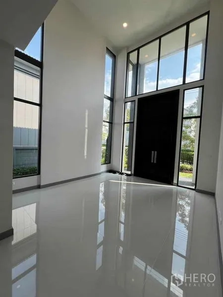 Detached House for rent in Khlong Sam Wa, Bangkok - Grand foyer with floor-to-ceiling glass panels and dark double entry doors.