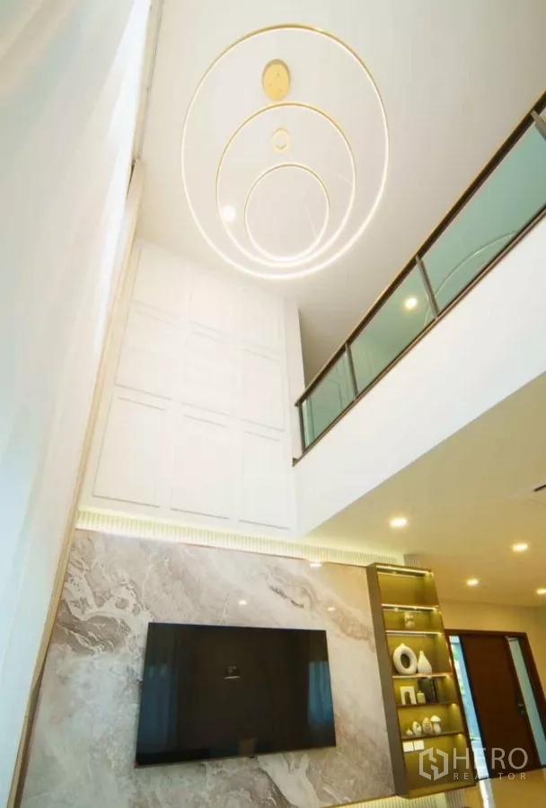 Detached House for rent or sale in Bang Phli, Samut Prakan - Double-height ceiling with circular light design and glass balustrade overlooking the living area.