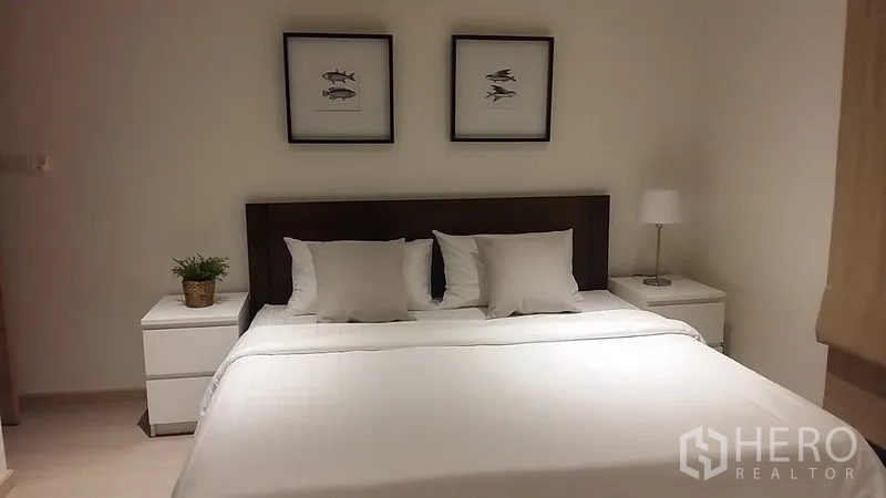 คอนโด ให้เช่าในWatthana, Bangkok - ห้องนอนใหญ่เตียงคิงไซซ์ โต๊ะข้างเตียง และไฟบรรยากาศอบอุ่น