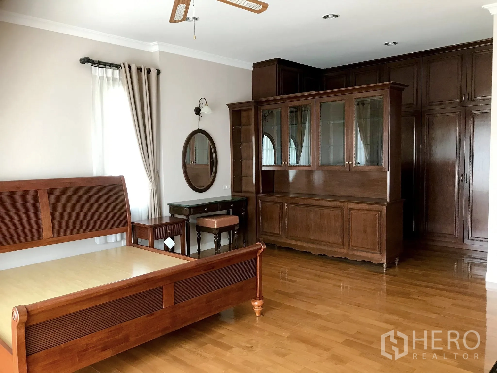 Detached House for rent in Mueang Samut Prakan, Samut Prakan - Master bedroom view showing extensive built-in wooden cabinetry and wardrobes.