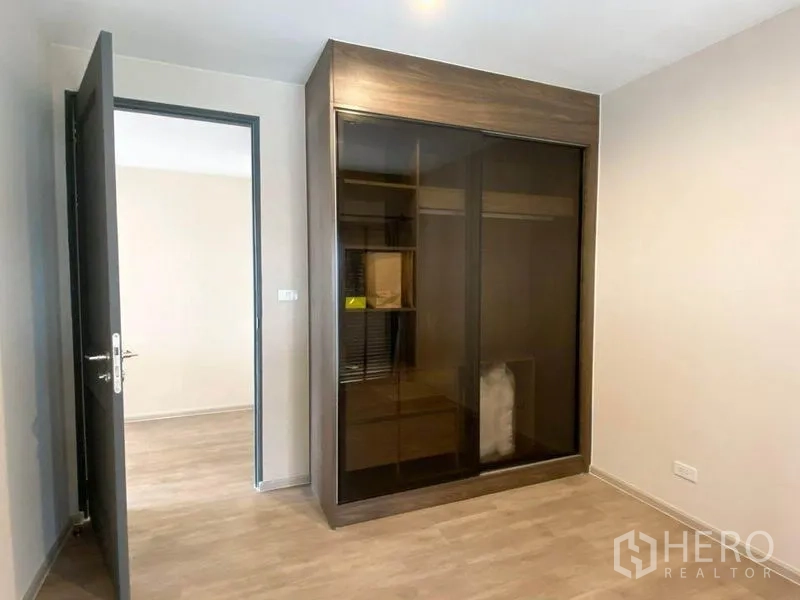 คอนโด ให้เช่าในPathum Wan, Bangkok - ห้องนอนที่สองมีตู้เสื้อผ้าบานเลื่อนกระจกสีเข้มและพื้นไม้