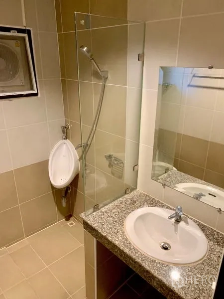 Detached House for rent in Khlong Sam Wa, Bangkok - Tiled bathroom with glass-enclosed shower, sink, mirror, and wall-mounted urinal.