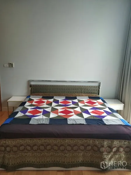 คอนโด ให้เช่าหรือขายในKhlong Toei, Bangkok - ห้องนอนสว่างพร้อมเตียงขนาดใหญ่ โต๊ะข้างเตียง และผนังโทนเรียบในคอนโดสุขุมวิท