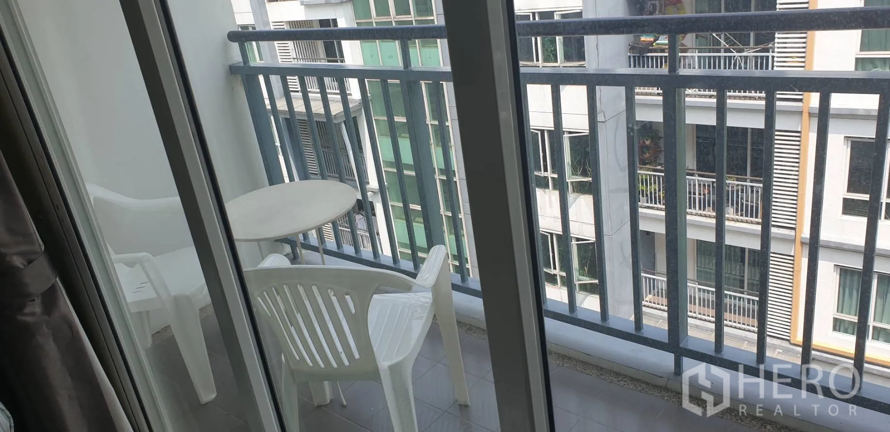 คอนโด ให้เช่าในKhlong Toei, Bangkok - ระเบียงแคบพร้อมโต๊ะกลมและเก้าอี้ 2 ตัว มองเห็นอาคารใกล้เคียง