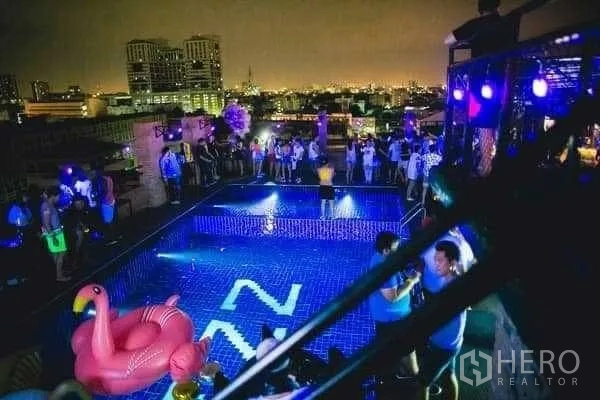 零售空间 出租在Khlong Toei, Bangkok - 夜间灯光下的屋顶泳池与城市景观。