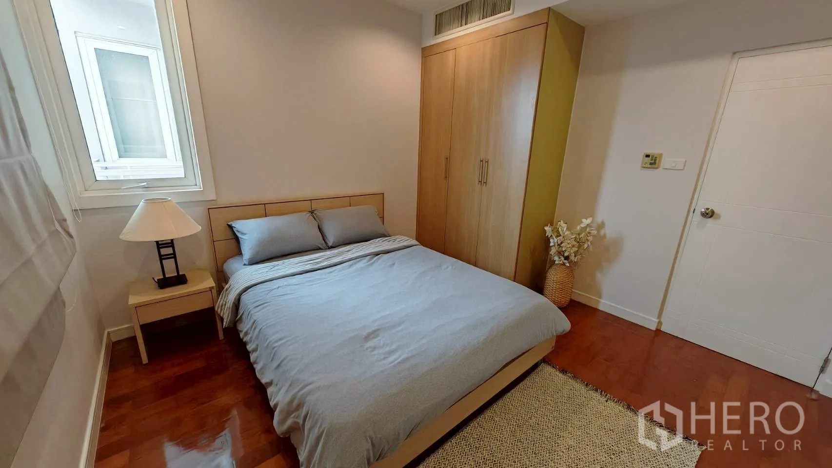Condominium for rent in Khlong Toei, Bangkok - Cozy bedroom with double bed, wardrobe and bedside lamp.