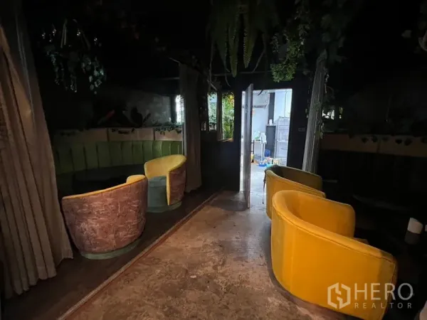 零售空间 出租在Watthana, Bangkok - 半私密卡座，黄色扶手椅与弧形长椅，靠近门口。