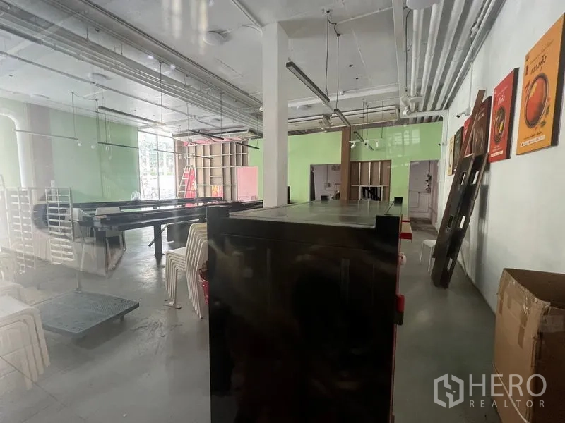 พื้นที่ขายปลีก ให้เช่าในHuai Khwang, Bangkok - ภายในร้านกว้างขวาง ไฟราง ผนังสีเขียว และกระจกบานใหญ่ด้านหน้า