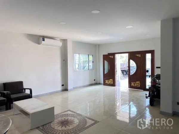 Warehouse for sale in Bang Phli, Samut Prakan - Bright ground-floor hall with ornate wooden double doors and polished tile flooring.