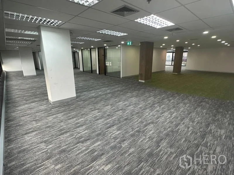 Office Space for rent in Khlong Toei, Bangkok - Spacious open workspace with columns, carpet tiles, and glass-partitioned offices.