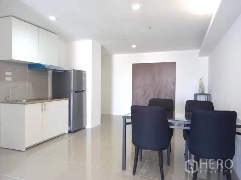 公寓 出租在Khlong Toei, Bangkok - 开放式小厨房，水槽、烟机、冰箱与四人餐桌。