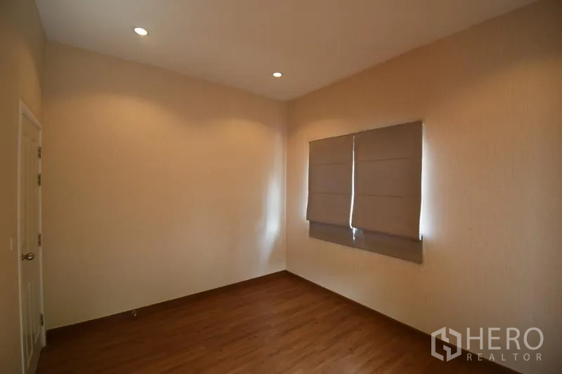 Detached House for rent in Prawet, Bangkok - Third bedroom with wood flooring, recessed lighting, and window blinds.