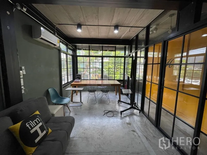 Home Office for sale - Bright meeting room with floor-to-ceiling windows, greenery views and industrial finishes.