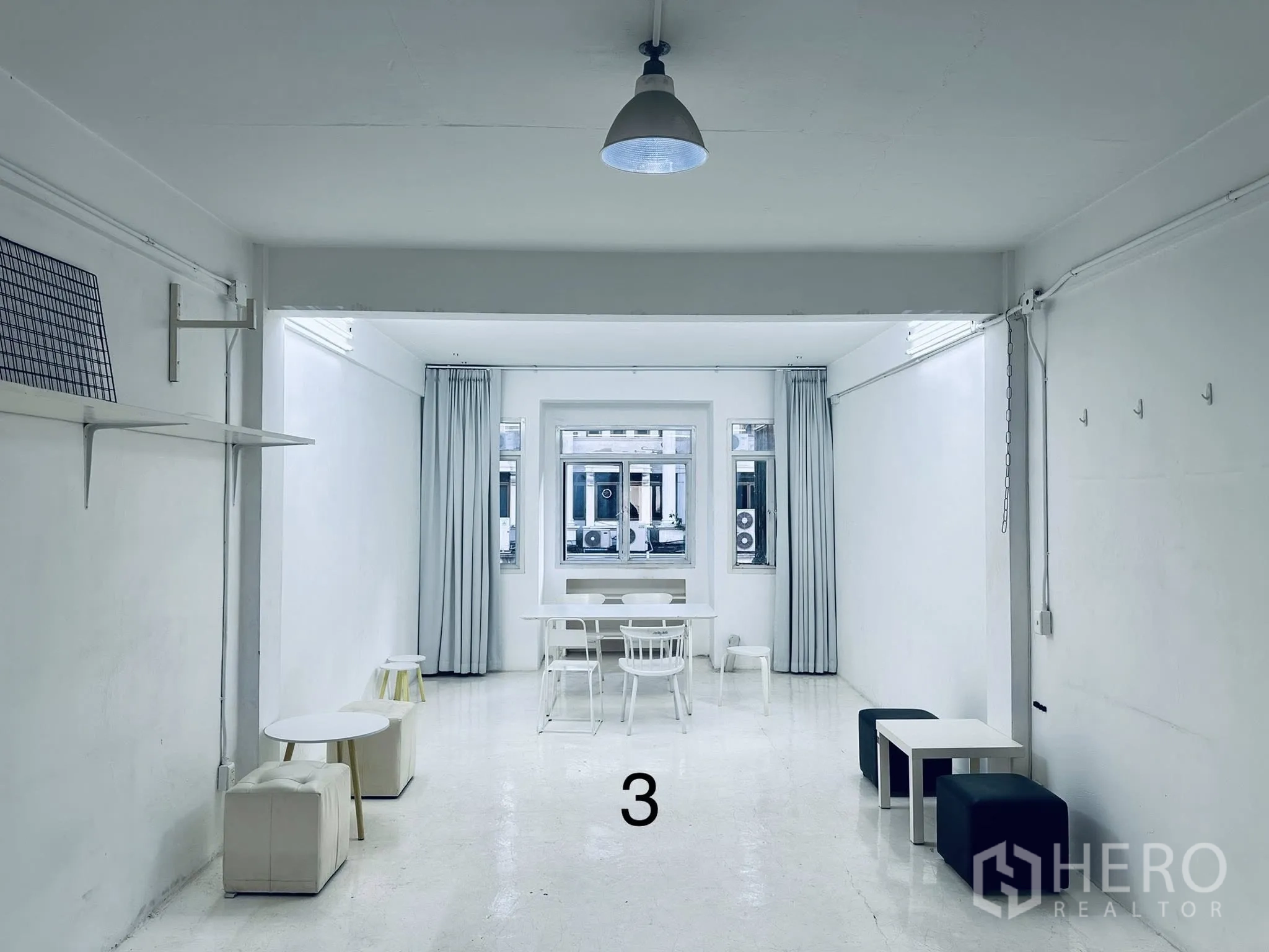 店屋 for rent in Watthana, Bangkok - 修长的白色房间，摆放方形座凳、小桌、窗户与顶灯。