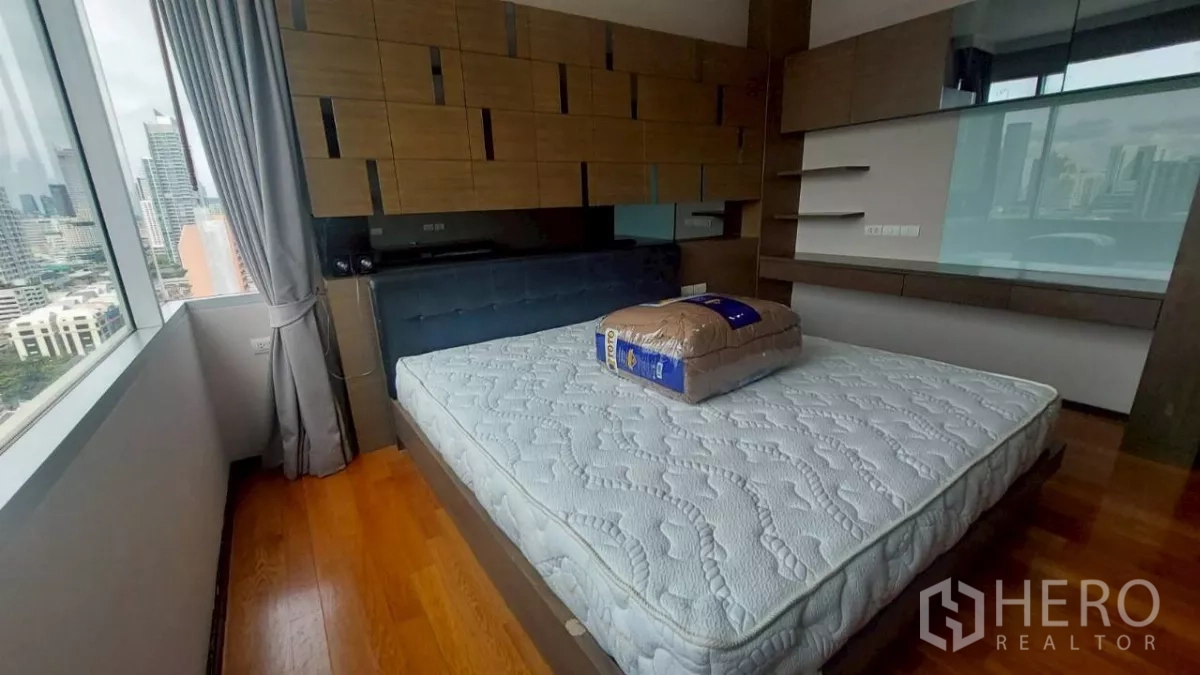 คอนโด ให้เช่าในKhlong San, Bangkok - ห้องนอนหลักพร้อมหน้าต่างใหญ่ พื้นไม้ หัวเตียงแผง และวิวเมืองกรุงเทพฯ
