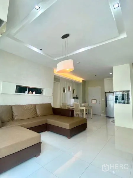 คอนโด ให้เช่าหรือขายในBang Kapi, Bangkok - ห้องนั่งเล่นแบบโอเพ่นแปลน โซฟาเข้ามุม โคมไฟแขวน และพื้นกระเบื้องมันวาว