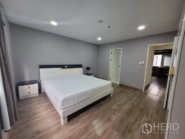 公寓 出租在Watthana, Bangkok - 宽敞主卧，配大床与木地板，墙面灰色系。