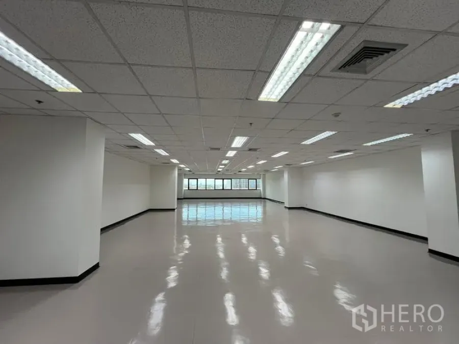 Office Space for rent or sale - Open office area featuring central air vents, grid ceiling, and natural light from full-length windows.