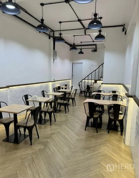 อาคารพาณิชย์ ให้เช่าในKhlong Toei, Bangkok - มุมพื้นที่นั่งรับประทาน โต๊ะกับเก้าอี้โลหะ ใต้โคมไฟสไตล์อุตสาหกรรม
