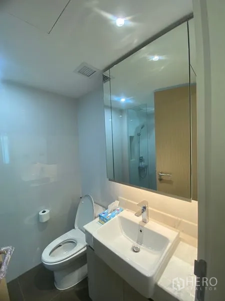 อพาร์ทเมนท์ ให้เช่าในWatthana, Bangkok - ห้องน้ำรองพร้อมอ่างล้างหน้าเดี่ยว ตู้กระจก และโถสุขภัณฑ์ในสไตล์มินิมอล