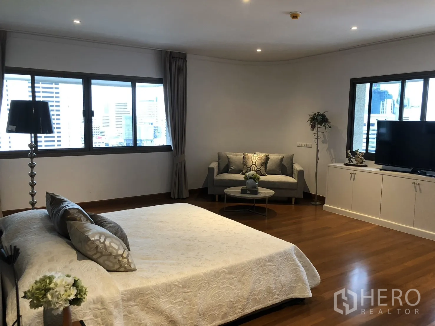 คอนโด ให้เช่าในBangkok - ห้องนอนมาสเตอร์มีมุมนั่งเล่น ตู้ทีวี และวิวเมือง