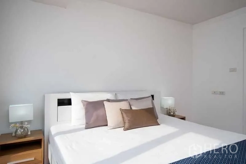 公寓 出租在Khlong Toei, Bangkok - 极简卧室一角，双人床、抱枕与两侧床头灯。