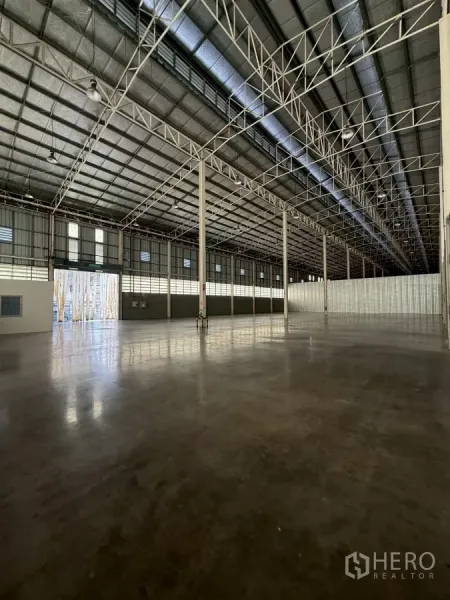 Warehouse for rent in Bang Sue, Bangkok - Entry view to the warehouse with large roller door, natural light and expansive floor area.