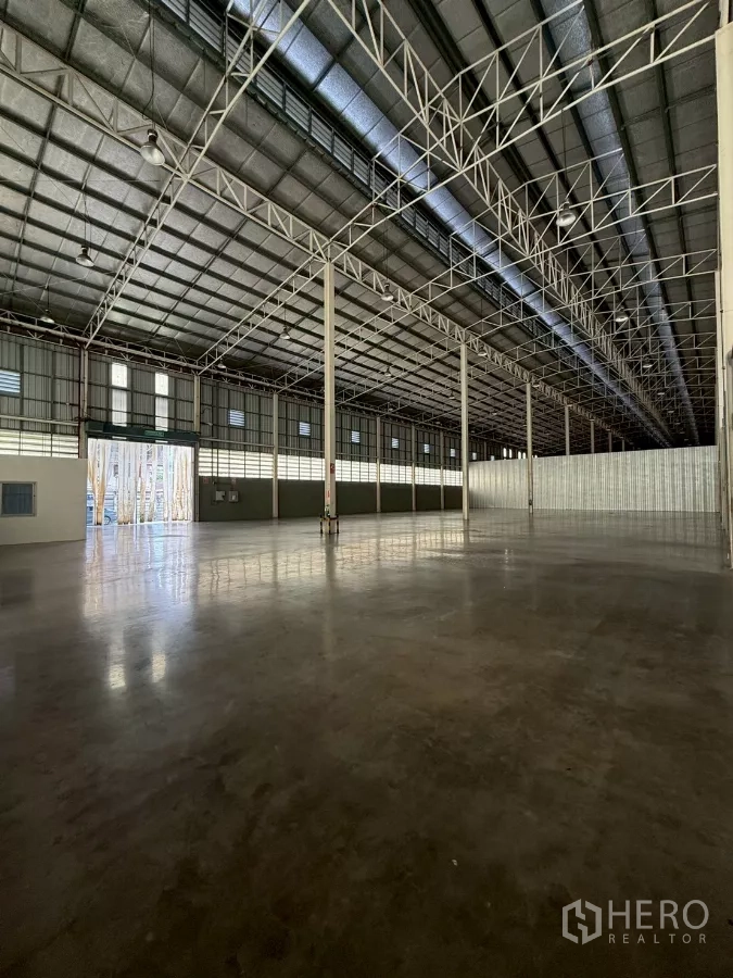Warehouse for rent in Bang Sue, Bangkok - Entry view to the warehouse with large roller door, natural light and expansive floor area.