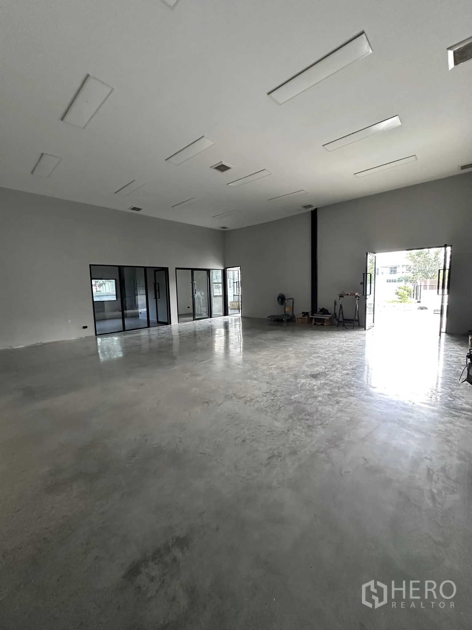 Warehouse for rent or sale in Prawet, Bangkok - Spacious warehouse interior with polished concrete floor, high ceiling and glass-partitioned offices.