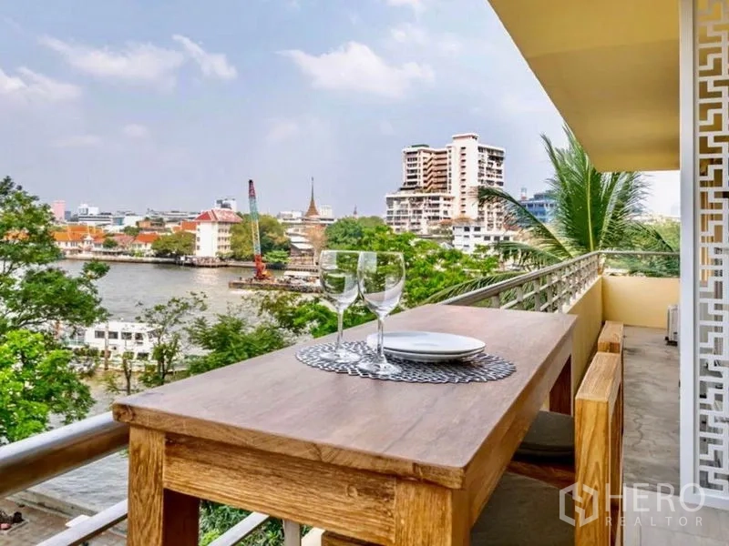 คอนโด ให้เช่าหรือขายในKhlong San, Bangkok - ระเบียงริมแม่น้ำพร้อมโต๊ะไม้ มองเห็นวิวแม่น้ำเจ้าพระยาและเส้นขอบฟ้าเมือง