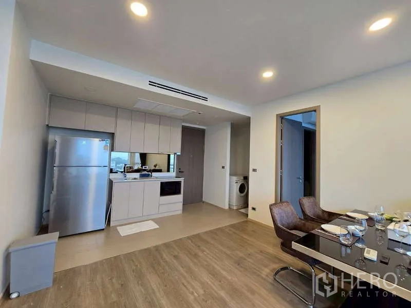 คอนโด ให้เช่าในPhaya Thai, Bangkok - ครัวเปิดสมัยใหม่พร้อมตู้เย็นสแตนเลส เตาไฟฟ้า และมุมทานข้าว มีมุมซักผ้าให้เห็น