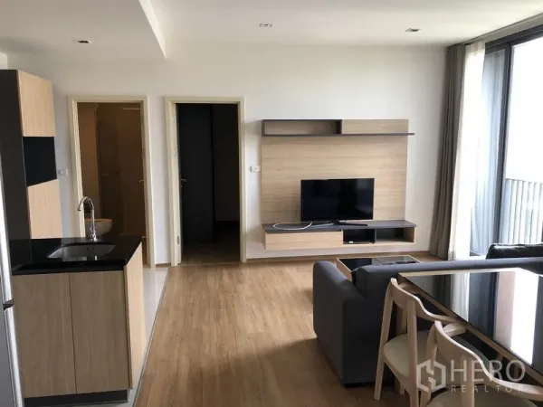 คอนโด ให้เช่าในWatthana, Bangkok - ห้องนั่งเล่นสว่าง ตู้วางทีวี หน้าต่างสูงจรดเพดาน และประตูเชื่อมไปยังห้องนอนและห้องน้ำ