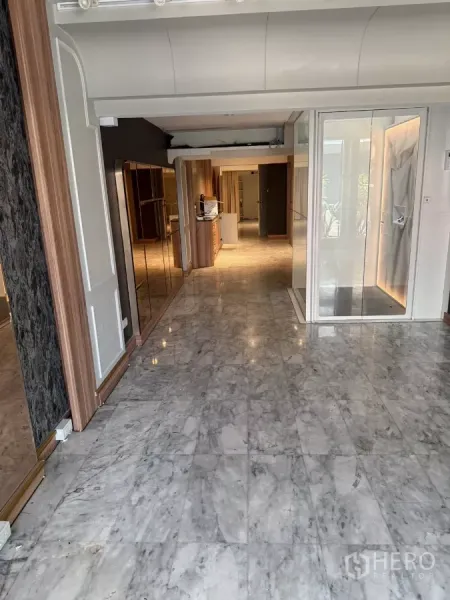 Shophouse for rent - Ground-floor interior with polished marble tiles, glass entry, and built-in wood cabinetry.