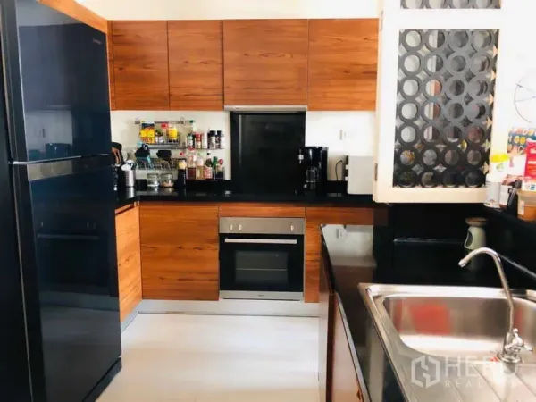 คอนโด ให้เช่าในWatthana, Bangkok - ครัวสมัยใหม่ ตู้ไม้ ท็อปหินสีดำ และเตาอบสเตนเลส.