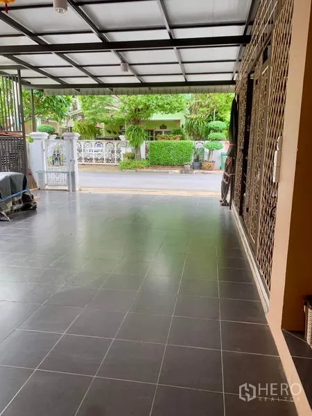 Detached House for rent in Khlong Sam Wa, Bangkok - View from covered carport toward quiet residential street and greenery.