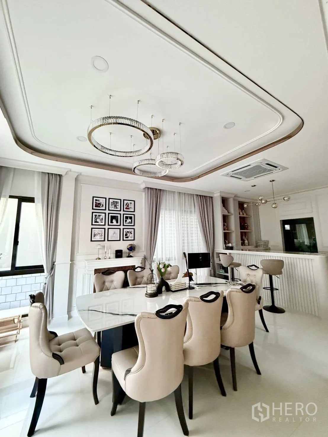 Detached House for rent in Wang Thonglang, Bangkok - Dining room with six upholstered chairs, bar counter, and contemporary pendant lights.