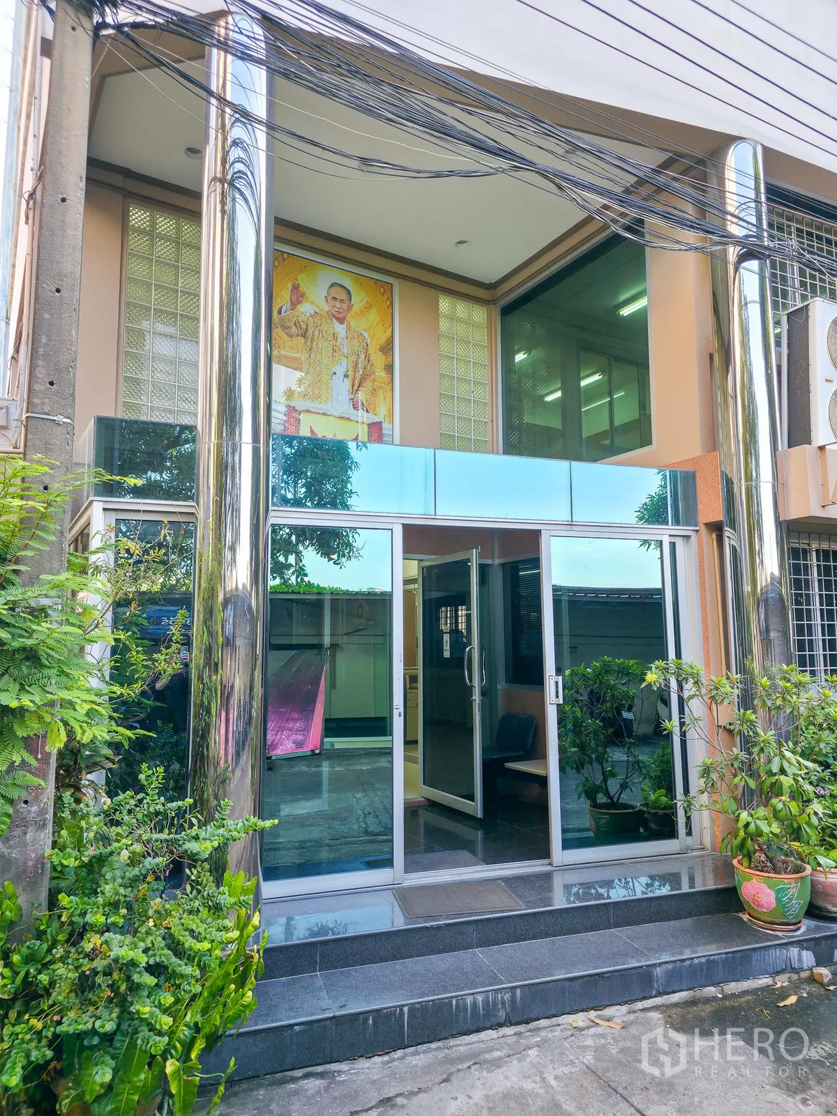 办公室 for rent in Khlong Toei, Bangkok - 大楼入口，玻璃门、金属立柱与盆栽绿植。