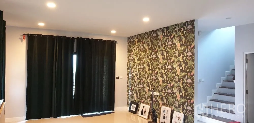 บ้าน ให้เช่าหรือขายในLam Luk Ka, Pathum Thani - ห้องนั่งเล่นผนังวอลเปเปอร์ลายดอก และบันไดขึ้นชั้นสอง