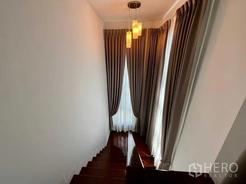 บ้าน ขายในBang Sao Thong, Samut Prakan - บันไดพื้นไม้พร้อมผ้าม่านสูงและโคมไฟแขวน